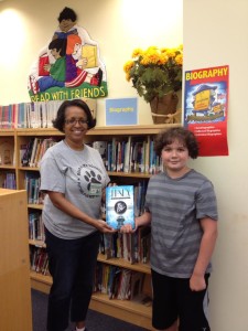 Kyle Driebeek donating a book to his school library
